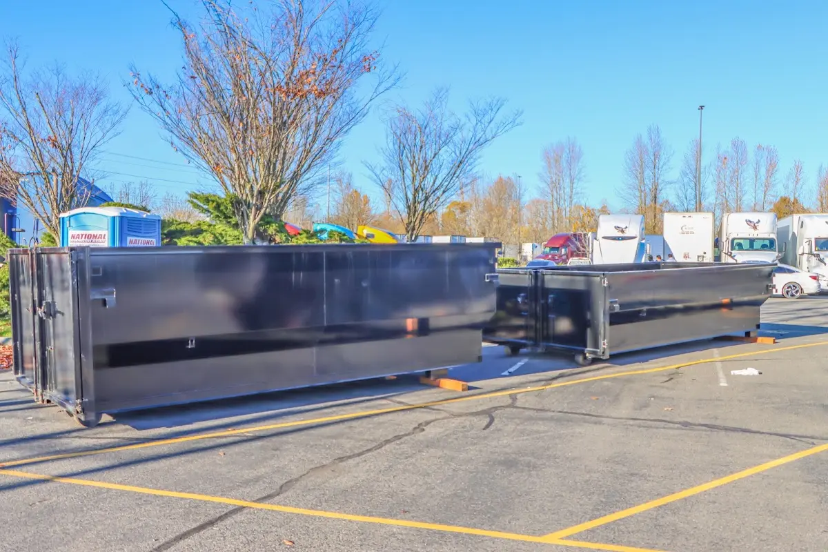 Professional dumpster rental service with roll-off container on residential driveway in Ashburnham